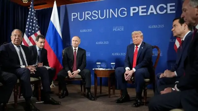 Putin ve Trump yanlarında delegeleri var. Arkada Barışı İzlemek yazılı bir ekran görünüyor. 
