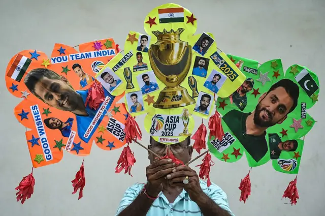 یو سړي د دواړو لوبډلو یو عکس په لاس کې نیولی دی