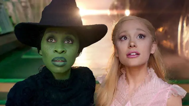 Cynthia Erivo y Ariana Grande miran fijamente a la cámara vestidas como Elphaba y Glinda, sus personajes de Wicked, en una escena de la película. Elphaba lleva un traje negro y un sombrero de bruja negro, y está pintada de verde. Glinda, por su parte, tiene el pelo rubio y lleva un vestido rosa.