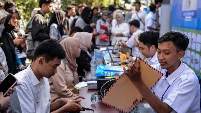 Petugas mengecek kelengkapan berkas pencari kerja saat bursa kerja di Kota Tangerang, Banten, Rabu (23/4/2025).