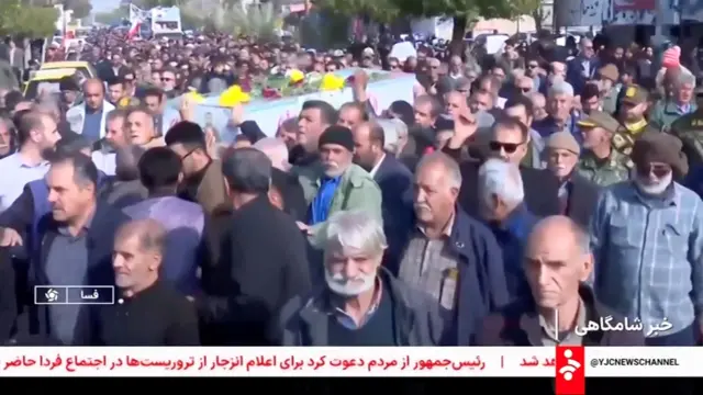 تصویری از تششیح پیکر تعدادی تعدادی از نیروهای امنیتی و غیرنظامیانی که شمار زیادی مردم در آن دیده می‌شوند. این تصاویر به گونه زنده در تلویزیون دولتی در حال نشر است.