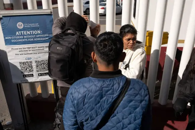 Migrantes en una puerta fronteriza cerrada de EE.UU.