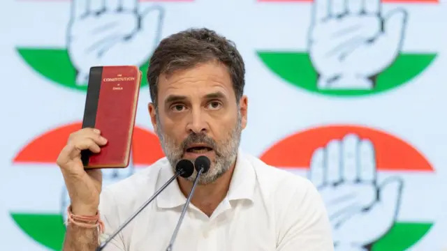 फोटोत राहुल गांधी भारतीय संविधान दाखवत आहेत.