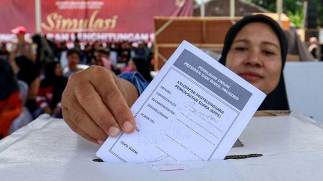 Warga memasukkan surat suara ke dalam kotak suara pada simulasi pemungutan dan penghitungan surat suara Pemilu 2024 yang digelar oleh KPU Banyuwangi di Lapangan Wirabumi, Srono, Banyuwangi, Jawa Timur, Minggu (28/1/2024). 