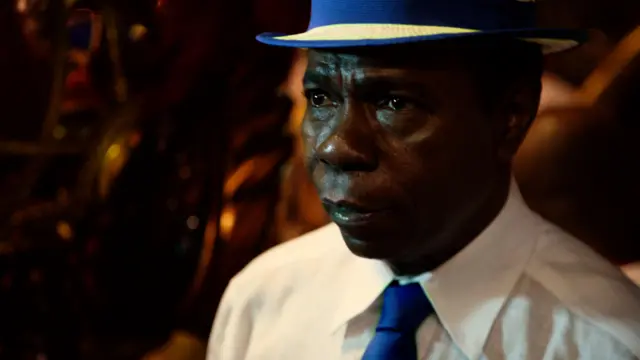 Paulinho da Costa usando uma gravata e um chapéu azul