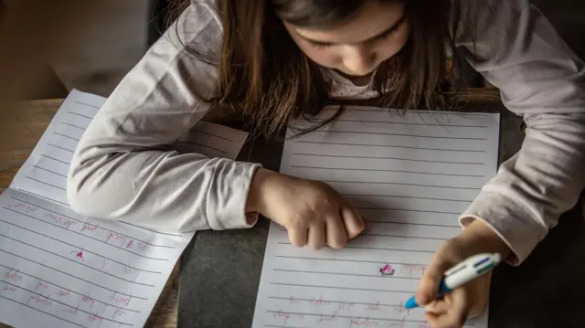 Menina escrevendo com a mão esquerda