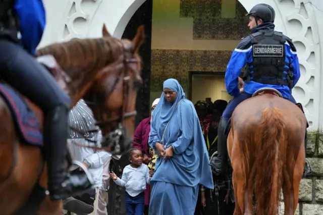 French gendarmes on their horses watch Muslim worshipers leaving the Great Mosque of Paris after the morning prayers on the first day of Islam's most important festival, the Feast of the Sacrifice (Eid al-Adha) on 16 June 2024 