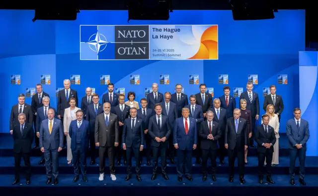 The Spanish Prime Minister is seen standing alone in the front row, far right, in a group photo of NATO leaders.