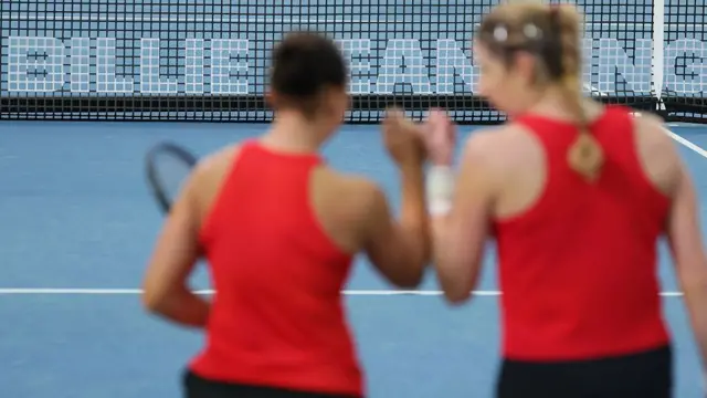 дві людини в червоних майках на тлі тенісного корту 