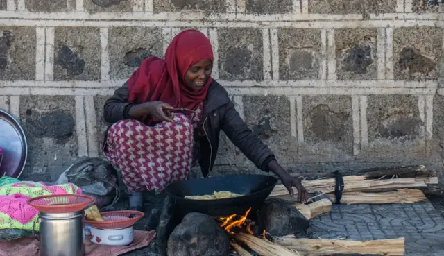 አሚናት ሠይድ ሳንቡሳ እየጠበሰች ስትሸጥ