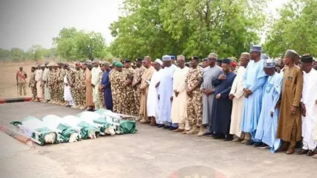 Pipo gada dey look caskets wey dem cover wit Nigeria flag we dey for ground