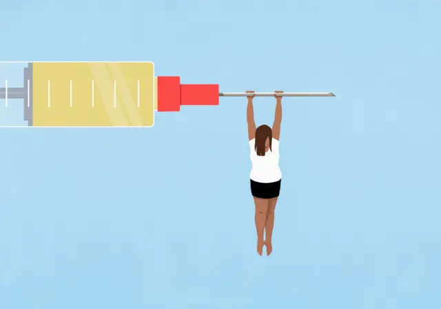 امرأة معلقة من محقنة كبيرة على خلفية زرقاء - صورة توضيحية أرشيفية