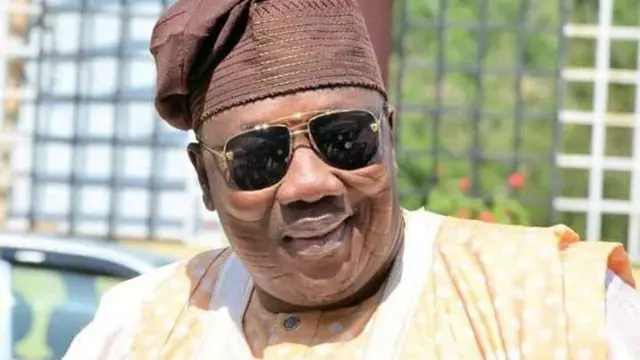Ọmọwe Najeem Folasayo Salaam wọ agbada, fila ati igo dudu