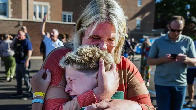 Una madre abraza a su hijo tras un tiroteo en la Iglesia de la escuela católica Annunciation, en Minneapolis, Minnesota, el miércoles 27 de agosto de 2025. 