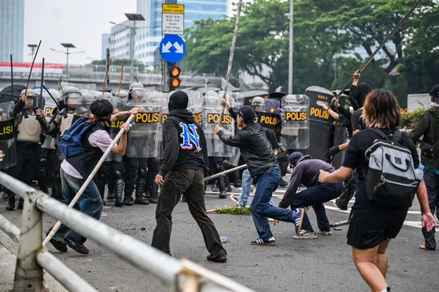 Personel polisi menghalau pengunjuk rasa di Jalan Letjend S Parman, depan Gedung DPR, Jakarta, Senin (25/08).