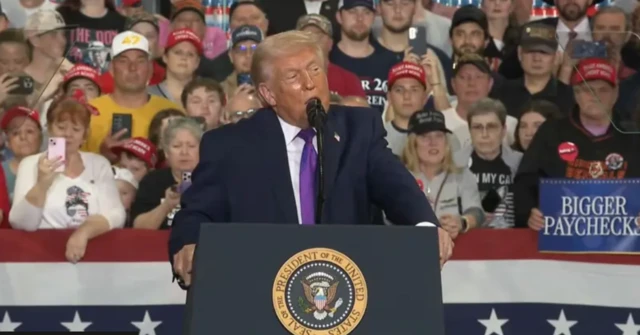 Trump arkasında destekçileriyle kürsüde konuşuyor.
