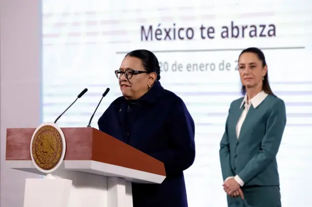 Claudia Sheinbaum detrás de la secretaria de Gobierno, Rosa Icela Rodríguez, durante la conferncia sobre el plan migratorio en México. 