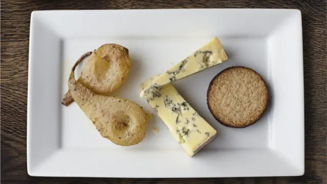 Груши, сыр и печенье на белой тарелке