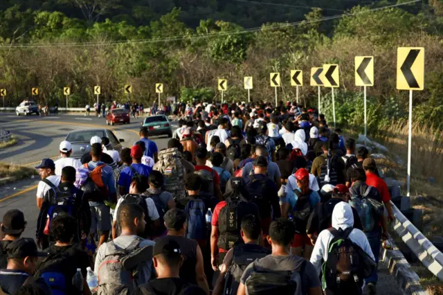 Migrants walk towards the US