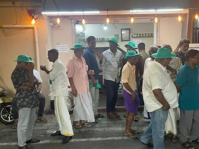 کوچی میں ایک چائے کی دکان پر انتخابی ریلی سے لوٹ رہے مسلم لیگ کے کچھ حامی سبز ٹوپیوں میں نظر آ گئے