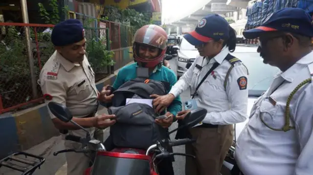 troje indijskih policajaca razgovara sa motoristom