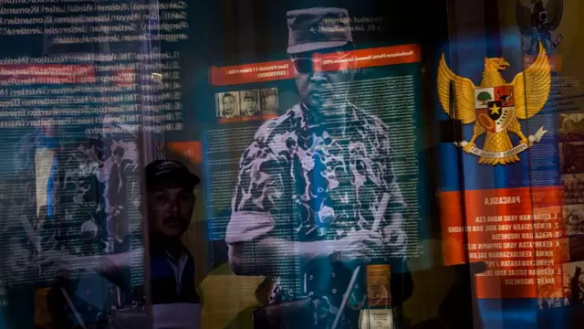 Foto Soeharto terlihat saat pengunjung berjalan di museum Soeharto. Para penyintas pembantaian anti-komunis menyerukan penyelidikan.