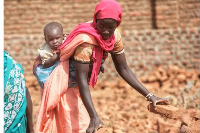 امرأة تحمل طفلا على ظهرها