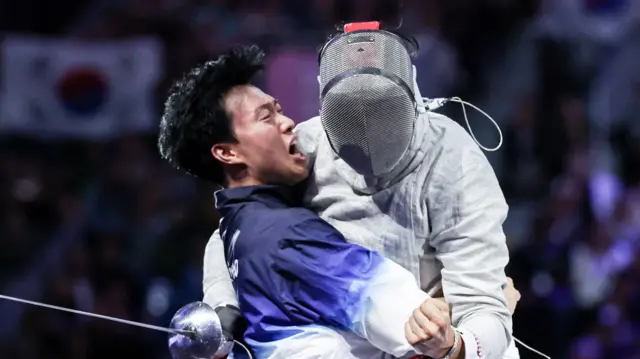 펜싱 대표팀 오상욱 선수가 28일(한국시간) 프랑스 파리 그랑 팔레에서 열린 2024 파리올림픽 남자 사브르 개인 튀니지 파레스 페라자니 선수와의 경기에서 금메달을 차지한 후 원우영 코치와 기뻐하고 있다