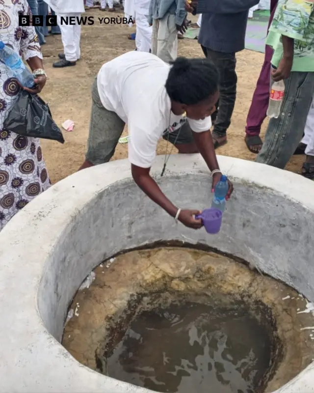 Kanga kan ti awọn onisẹse n bọ, ọkunrin kan duro, o n da nnkan etutu sinu kanga naa, ti awọn onisẹse yoku si yii ka