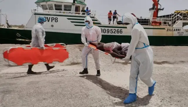 Socorristas tirando sobreviventes do barco