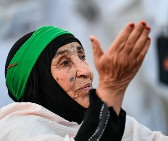 حاجة مسلمة تصلي على جبل عرفات أثناء موسم حج 2024، جنوب شرق مكة، المملكة العربية السعودية، 15 يونيو/حزيران 2024.