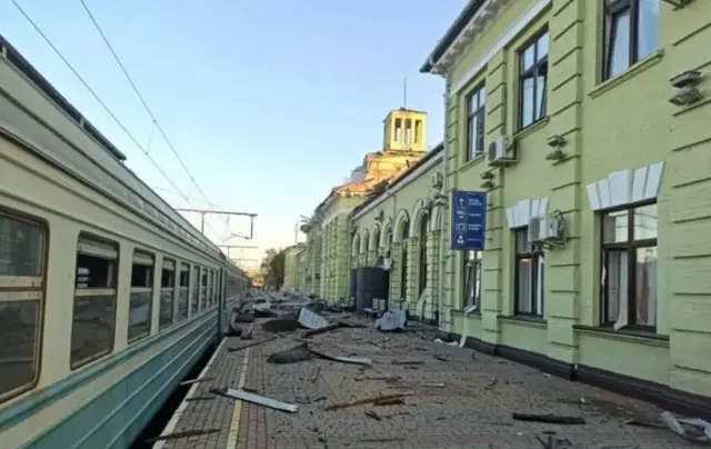 Жовта будівля залізничної станції, вагон на пероні - всюди вибиті вікна. На пероні валяються шматки скла і цегли