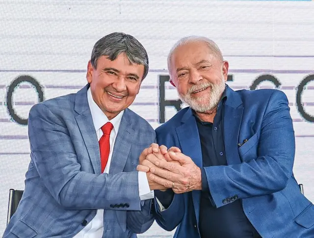 Dias e Lula de mãos dadas e sorrindo
