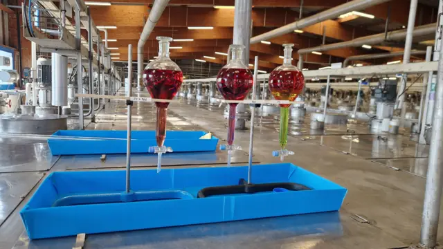 Vials show demonstrate how neodymium and praseodymium are separated from a mixture of rare earths in the vast vats that fill the room 