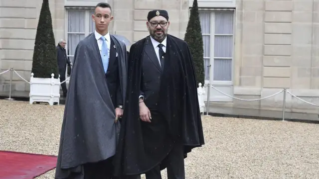 Sarki Mohammed na shida shi ne sarki na 23 a sarautar kasar ta mabiya ɗariƙar Alawi da ke mulkin Moroko tun 1640 (Alaouite dynasty). Sarkin ne tsaye da Yarima mai jiran-gado Moulay Hassan, a fadar gwamnatin Faransa (Élysée Palace) a lokacin wani taro da Shugaban Faransa Emmanuel Macron ya shirya domin cika shekara ɗari da kawo ƙarshen yaƙin duniya na farko, ranar 11 ga watan Nuwamban 2018 a Paris.
Sarkin ne tsaye da Yarima mai jiran-gado Moulay Hassan, a fadar gwamnatin Faransa (Élysée Palace) a lokacin wani taro da Shugaban Faransa Emmanuel Macron ya shirya domin cika shekara ɗari da kawo ƙarshen yaƙin duniya na farko, ranar 11 ga watan Nuwamban 2018 a Paris.