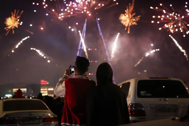 شاب يصور ألعاباً نارية وعروض في السماء خلال الاحتفال برأس السنة في العاصمة البحرينية المنامة
