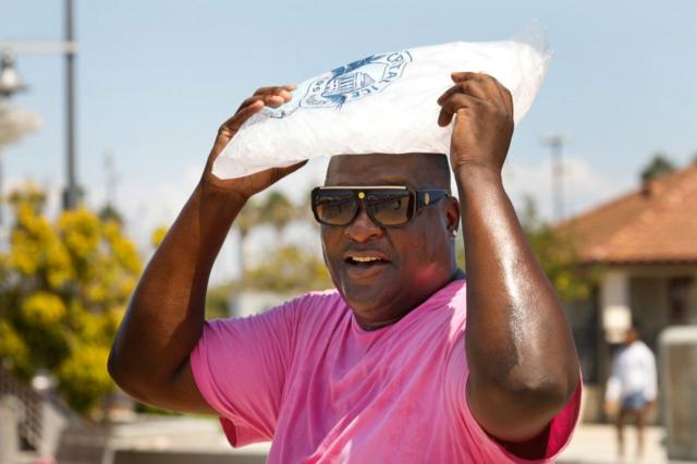 Un homme transportant un sac de glace sur la tête 