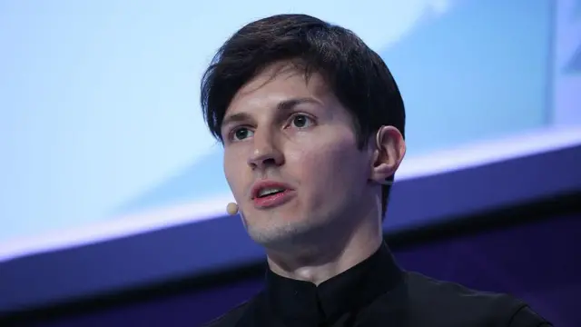 Pavel Durov fala durante evento; ele veste camisa preta e usa microfone headset