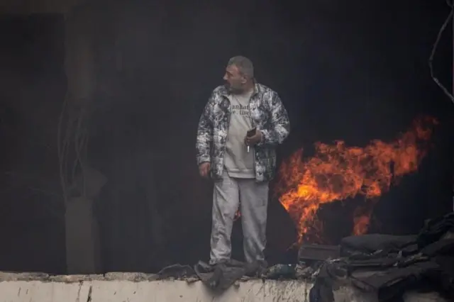 Mwanamume amesimama ndani ya jengo lililoharibiwa huko Beirut