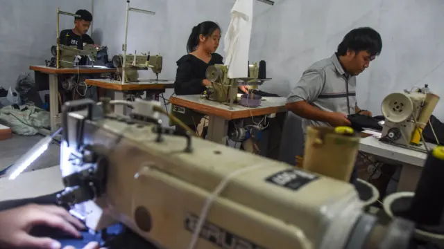 Sejumlah pekerja konveksi menjahit celana gunung dan jaket parasut di rumah produksi Hextstudio, Desa Margahayu, Kecamatan Manonjaya, Kabupaten Tasikmalaya, Jawa Barat, Selasa (13/1/2026).