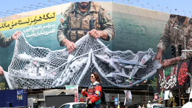 „Ормуски мореуз ц́е остати затворен“, пише на великом плакату у центру Техерана, уз фотографију како иранска војска хвата у мрежу непријатељске бродове и авионе