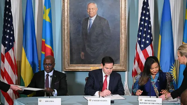 Minisitiri w'ububanyi n'amahanga w'u Rwanda Olivier Nduhungirehe na Minisitiri w'ububanyi n'amahanga wa DRC Thérèse Kayikwamba ubwo bashyiraga umukono ku masezerano y'amahoro muri minisiteri y'ububanyi n'amahanga y'Amerika, imbere ya Minisitiri Marco Rubio (hagati). Ifoto yafotorewe i Washington DC, ku itariki ya 27 Kamena (6) mu mwaka wa 2025. 