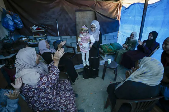Mujeres palestinas celebran el regreso de la pequeña Bisan con su madre.