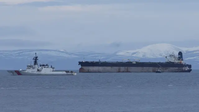 Marinera пришвартована поруч із судном Берегової охорони США у затоці біля узбережжя Шотландії на тлі засніжених пагорбів та важкого зимового неба