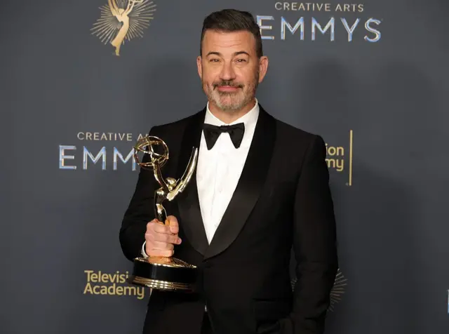 Jimmy Kimmel pose wit im award