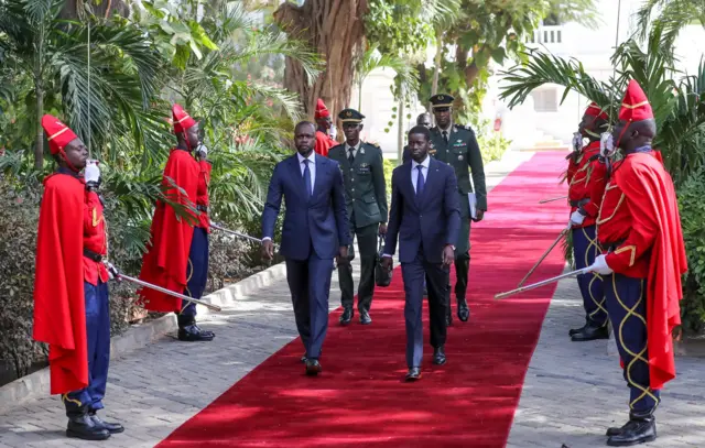 Bassirou Diomaye Faye (droite) et Ousmane Sonko marchent côte à côte au palais de la République.