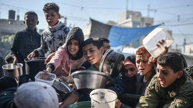 Niños en una multitud luchan por recibir comida