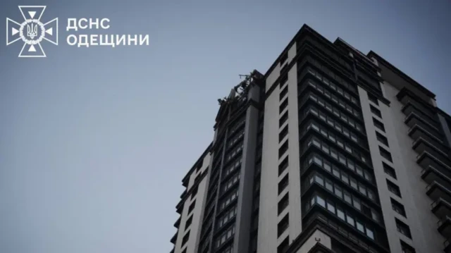 Многоэтажный дом, на верхних этажах которого видны повреждения 