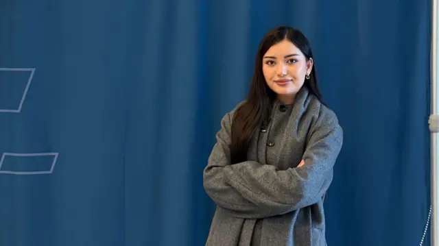 فوزیه محمدی در دانشگاه حقوق دیکینسون در پنسیلوانیا، مقابل کمره ایستاده و با لبخندی آرام عکس می‌گیرد. 