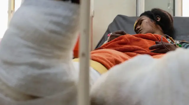 Femme blessée sur un lit d'hôpital